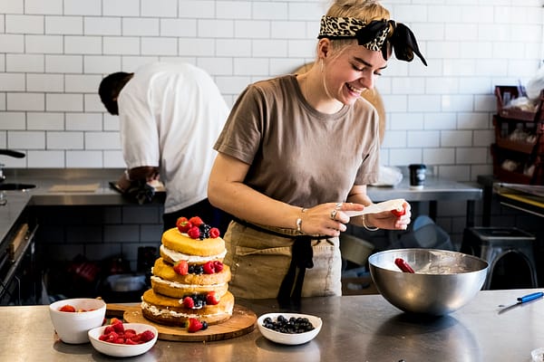 a-cook-working-in-a-commercial-kitchen-assembling-a-layered-sponge-cake-with-fresh-fruit-.jpg a-cook-working-in-a-commercial-kitchen-assembling-a-layered-sponge-cake-with-fresh-fruit-.jpg